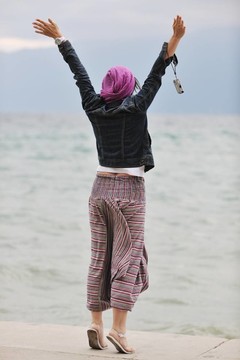 美麗的年輕女子在海灘與圍巾