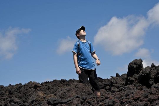 步行穿過火山區(qū)的男孩