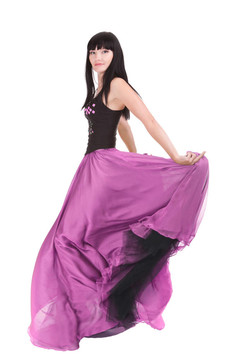 美麗的女人在她的時(shí)尚色彩的衣服旋轉(zhuǎn)