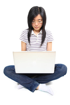 年輕的中國女人坐在地板上用筆記本電腦