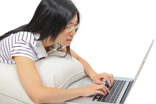 年輕的中國女人坐在地板上用筆記本電腦