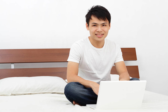 躺在床上的男人用他的筆記本電腦
