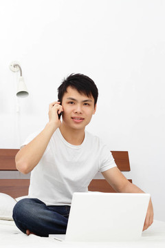 男子在手機(jī)上用筆記本電腦