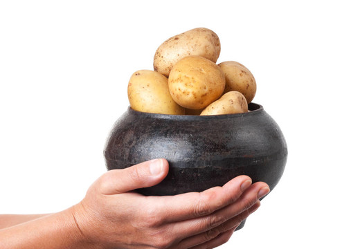 手里拿著土豆的鑄鐵鍋