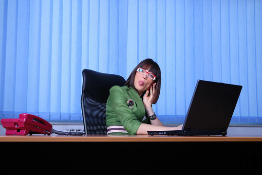 年輕的女商人，正在辦公室里一臺筆記本電腦。