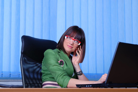 年輕的女商人，正在辦公室里一臺筆記本電腦。