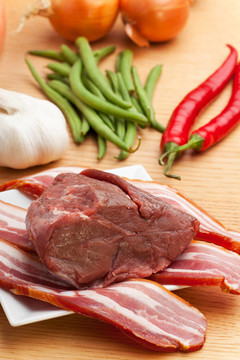 木制桌上的生肉和熏肉條紋