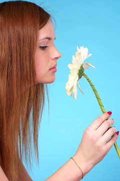 漂亮的年輕女人嗅白花