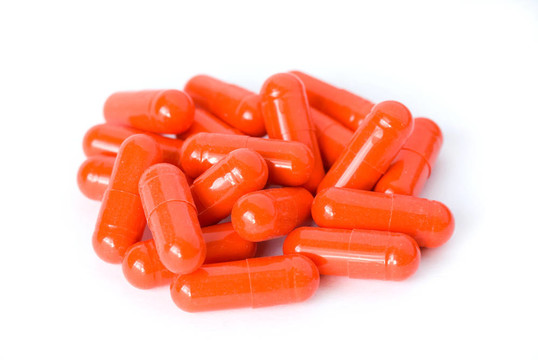 堆的紅色藥丸或膠囊