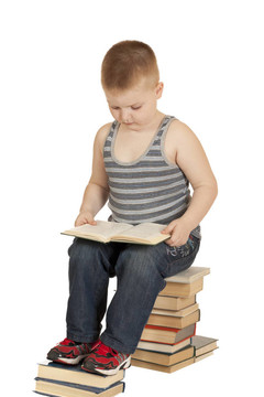 小男孩坐在書上看書