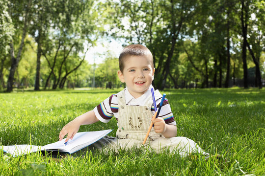 一個男孩在公園里拿著一本書的肖像