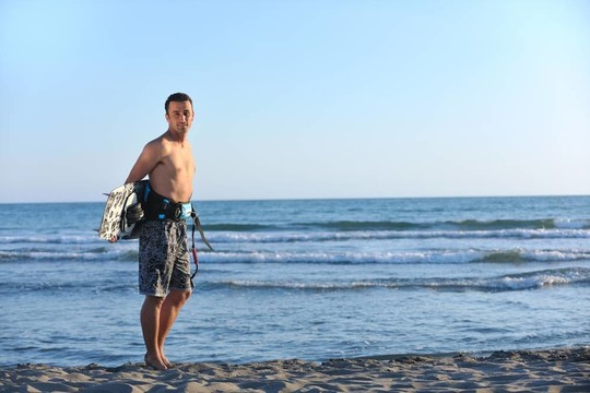 一個年輕人在海灘上的日落kitsurf肖像