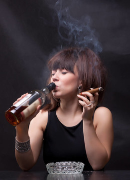 女人喝酒和抽雪茄的照片