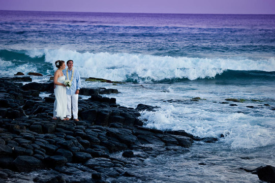 剛剛結(jié)婚。美麗的年輕夫婦在巖石海岸。