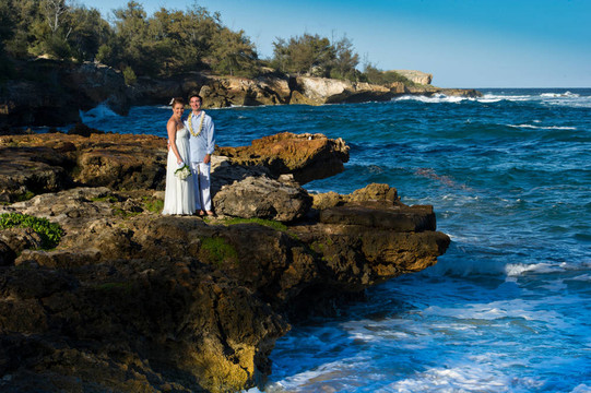 剛剛結(jié)婚。美麗的年輕夫婦在巖石海岸。