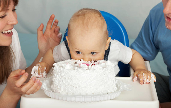 小孩吃蛋糕。家人慶祝兒子的第一個生日。