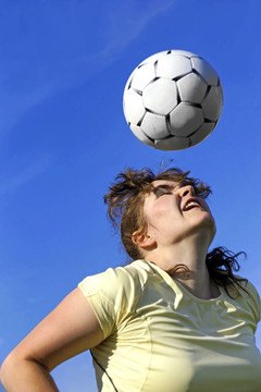 由年輕女子足球運動員頭球
