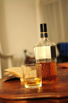 一杯威士忌；酒瓶和打開的書