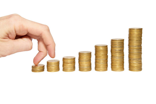 攀登手上的金幣樓梯上的白色隔離。