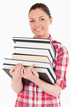 迷人的女性擺著書站著