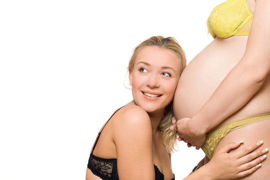 快樂的年輕女人和肚子里懷孕的女友