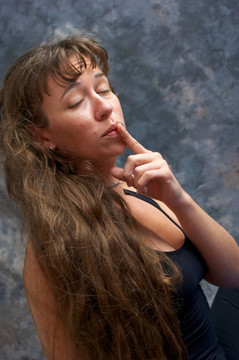 美麗的女人用手指到嘴唇