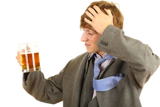 喝醉的年輕商人穿著灰色西裝和啤酒