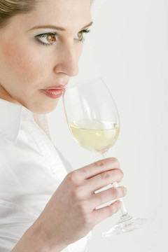 年輕女人品嘗白葡萄酒的肖像