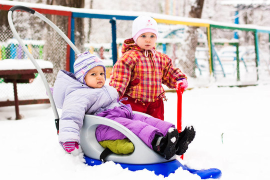 孩子們在雪地里玩雪橇和鐵鍬