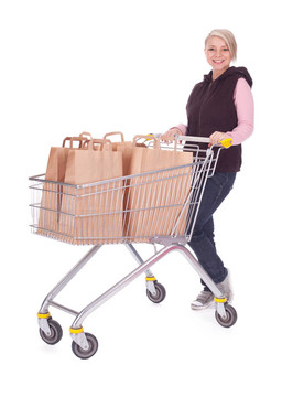 年輕女子購(gòu)物車(chē)裝滿(mǎn)文件袋