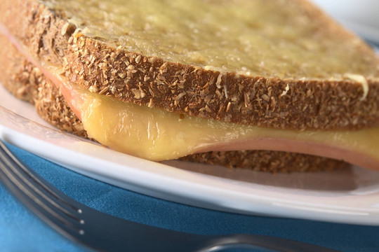 Croque Monsieur。烤全麥面包三文治火腿奶酪和磨碎的奶酪在上面（選擇性聚焦；對夾層左前邊
