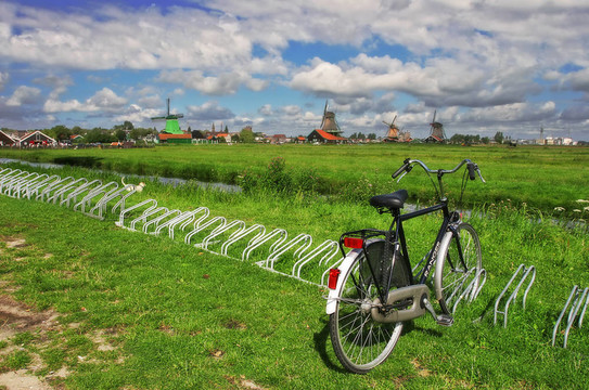 在風車的背景下，在綠色的草坪上的自行車。