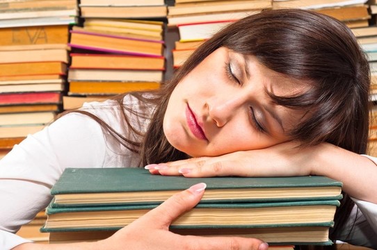 勞累的大學生睡在她的書