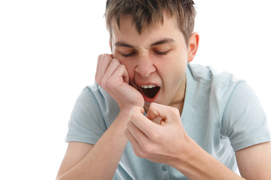 打哈欠的疲倦或無聊的男孩