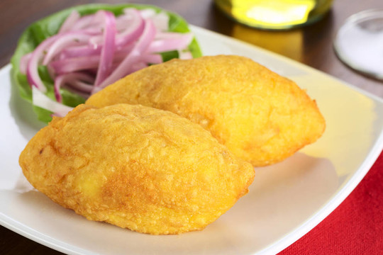秘魯菜叫Papa Rellena（釀土豆）做成土豆泥和夾肉（選擇性聚焦；在第一次爸爸rellena右