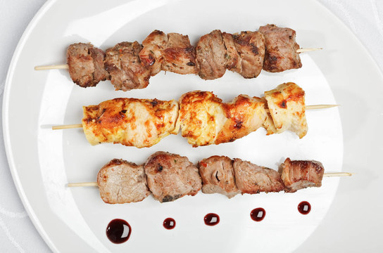 雞；豬肉和牛肉串在白色板