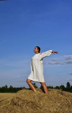 在傳統(tǒng)的俄羅斯服裝站在干草堆里的女孩