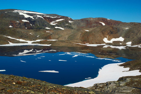 湖四周荒蕪的部分積雪覆蓋山脈靠近挪威北部sulitjelma
