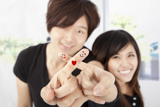 幸福的夫妻的微笑的手指
