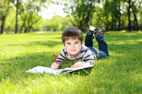 一個(gè)男孩在公園里拿著一本書的肖像