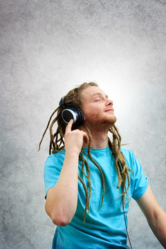 一個(gè)長(zhǎng)發(fā)綹上耳機(jī)聽音樂(lè)的年輕人的肖像
