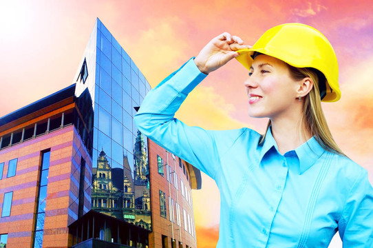 站在建筑物背景上的年輕建筑師女士戴著防護(hù)頭盔