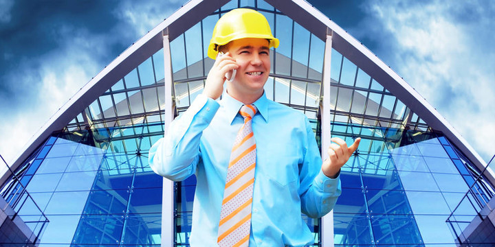 站在建筑物背景上的年輕建筑師戴著防護頭盔