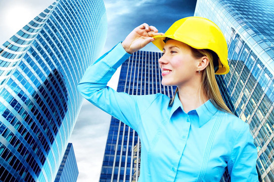 站在建筑物背景上的年輕建筑師女士戴著防護(hù)頭盔