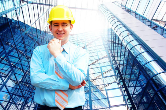 站在建筑物背景上的年輕建筑師戴著防護(hù)頭盔