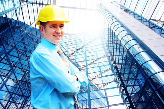 站在建筑物背景上的年輕建筑師戴著防護頭盔