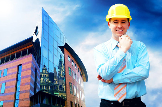 站在建筑物背景上的年輕建筑師戴著防護(hù)頭盔