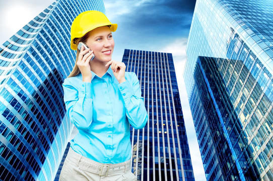 站在建筑物背景上的年輕建筑師女士戴著防護(hù)頭盔