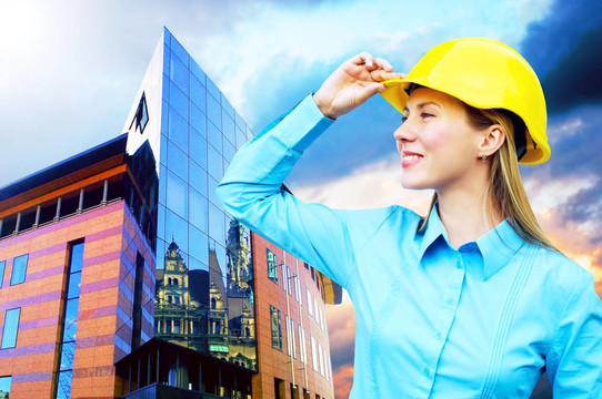 站在建筑物背景上的年輕建筑師女士戴著防護(hù)頭盔