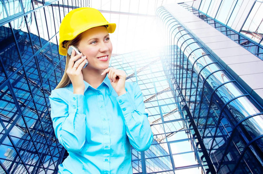 站在建筑物背景上的年輕建筑師女士戴著防護(hù)頭盔